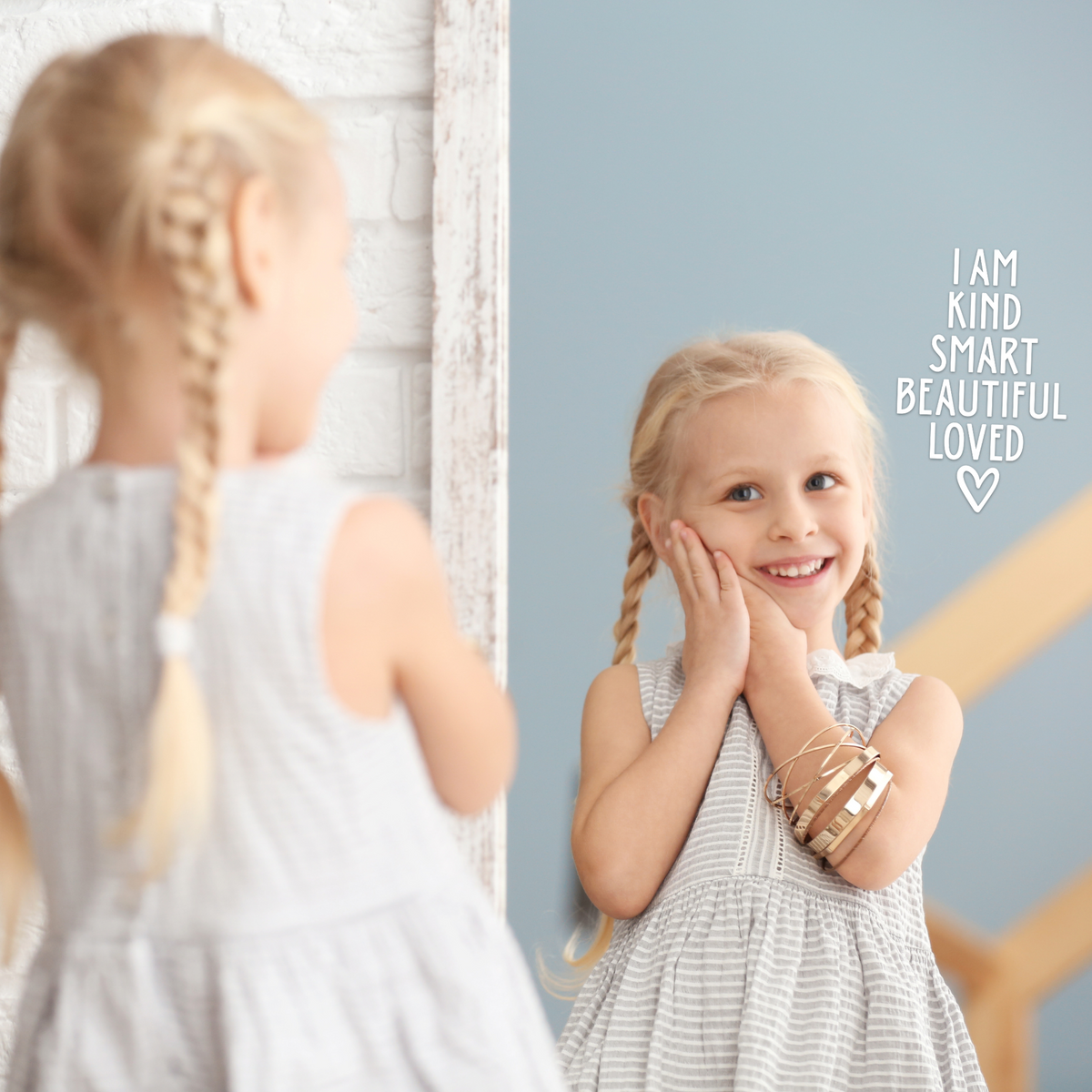 Girl looking into mirror that has a positive affirmation decal sticker on it. The decal says "I am kind, smart, beautiful, loved."